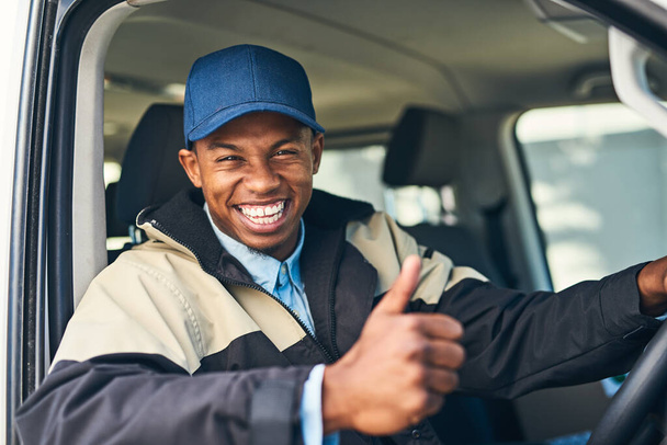 We promise the most reliable service to you. Portrait of a courier showing thumbs up while driving a delivery van - Fotografie, Obrázek