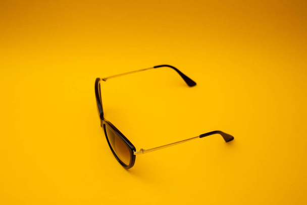 Black s sunglasses on orange background - Fotoğraf, Görsel