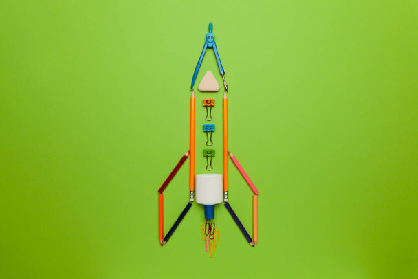 Spaceship (rocket) from stationery on green background. Child imagination, science in elementary school. (preschool) - Фото, изображение