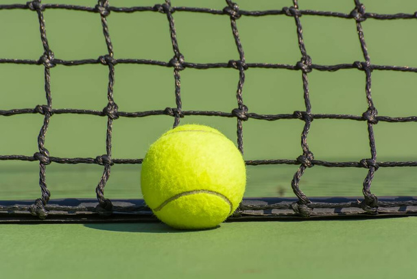 A yellow tennis ball in court - Foto, afbeelding