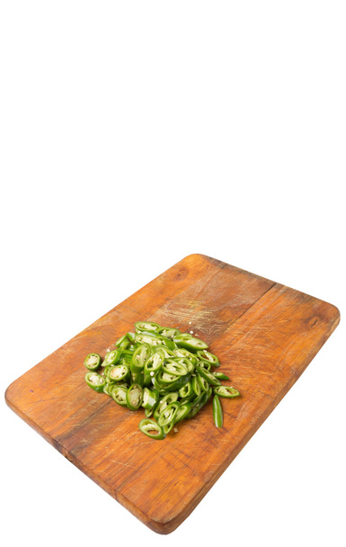 Nasekané zelené chilli papričky na dřevěné prkénko nad bílým pozadím - Fotografie, Obrázek