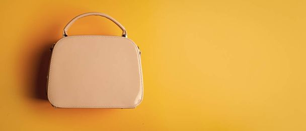 fashionable leather bag on yellow background. shopping store concept. female leather stylish bag. fashion accessory. copy space. - Фото, зображення