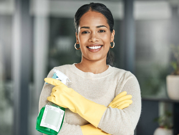 Cleaning, hygiene and chores with a spray bottle while wearing gloves and smiling at home. Portrait of a happy woman, cleaner or housewife ready to do housework to keep things neat, tidy and fresh. - Fotó, kép