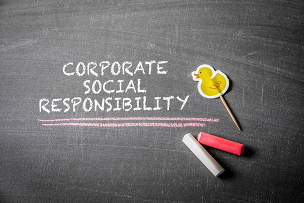 Corporate Social Responsibility. Text and pieces of chalk on a blackboard. - Foto, Bild