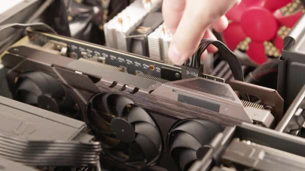 caucasian hand unplugging 8-pin ATX auxiliary power cable in graphics card during new hardware installation - Video, Çekim