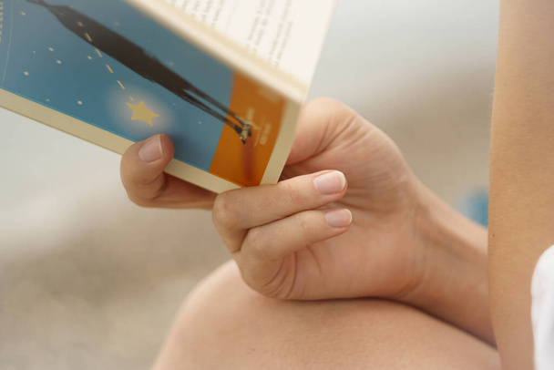 Macro shot of woman reading book at the beach - Foto, afbeelding