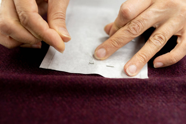 Τα χέρια των γυναικών ράβουν κομμάτια υφάσματος σε μια ραπτομηχανή από κοντά. οριζόντιο πλαίσιο - Φωτογραφία, εικόνα