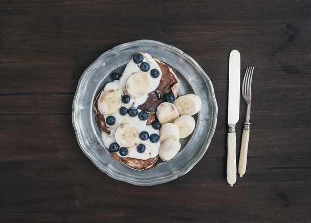 Breakfast set on dark wooden desk: apple and cinnamon pancakes w - Фото, зображення
