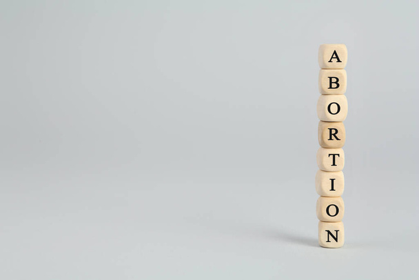 Word Abortion made of wooden cubes on light grey background. Space for text - Fotografie, Obrázek