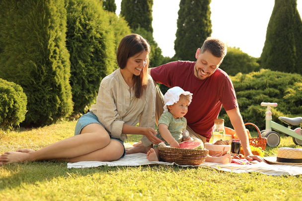Happy family having picnic in garden on sunny day - 写真・画像