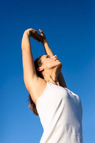 Vrouwelijke atleet, die zich uitstrekt armen voor de uitoefening van en ontspannen - Foto, afbeelding