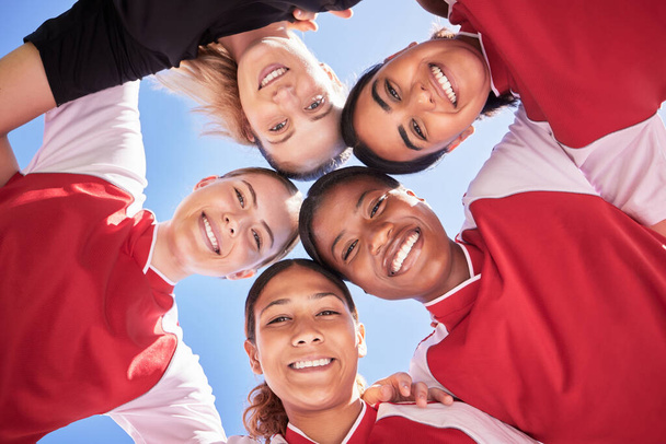 Female soccer team huddle bonding, smiling or motivated in circle with heads in middle. Below portrait of fit, active and diverse group of football girls, friends or athletes at sports, match or game. - Valokuva, kuva