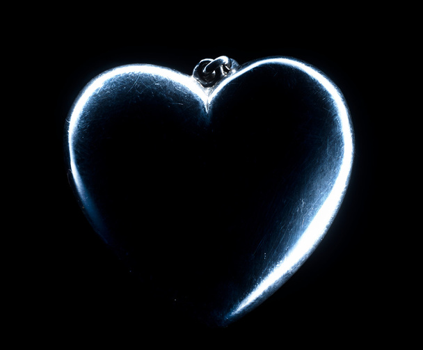 Forma del corazón emergiendo de un fondo negro
. - Foto, imagen