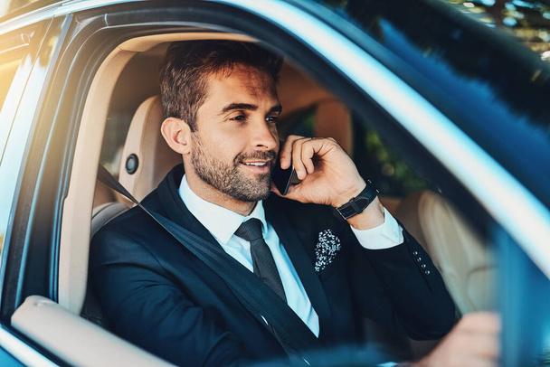 Making success happen from the comfort of his car. a handsome young corporate businessman on a call while commuting - Фото, изображение