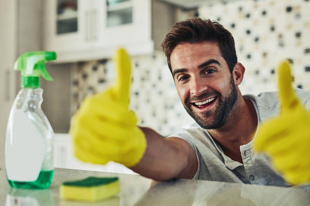 Housework is not just for women. a handsome young man cleaning his home - 写真・画像