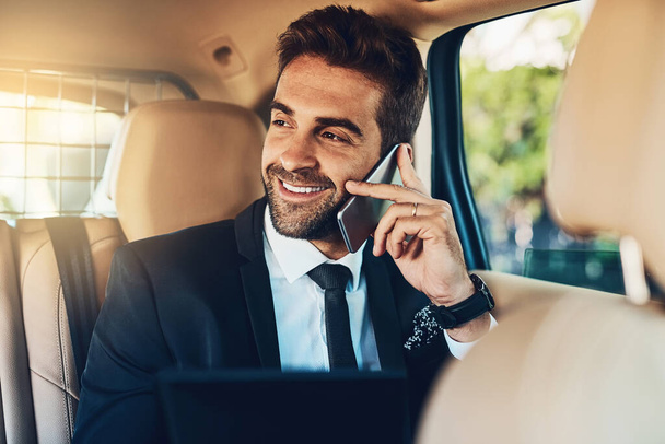 Thats great news, Ill be there shortly. a handsome young corporate businessman on a call while commuting - Fotografie, Obrázek