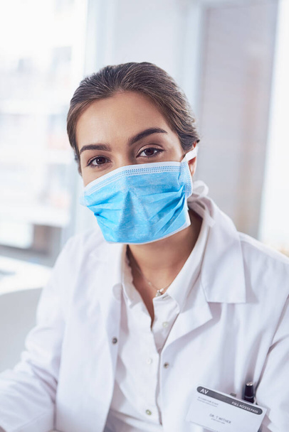 She is geared up and ready for science. Portrait of a confident young female scientist wearing a surgical mask while looking at the camera - Photo, Image