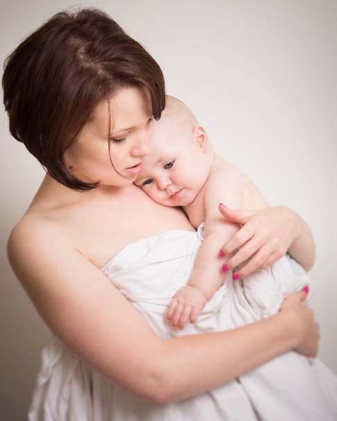 Fiatal Anya gyermekével meghitt ölelés - Fotó, kép