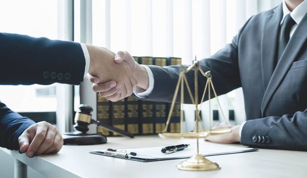 Handshake after Lawyer  providing legal consult business dispute service to the man at the office with justice scale and gavel hammer. - Photo, Image