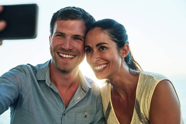 Never miss a good selfie moment. a happy couple taking a selfie while out on a date - Foto, afbeelding