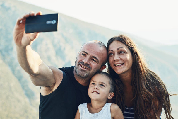 And now for a family selfie. a family of three taking a selfie together - Zdjęcie, obraz