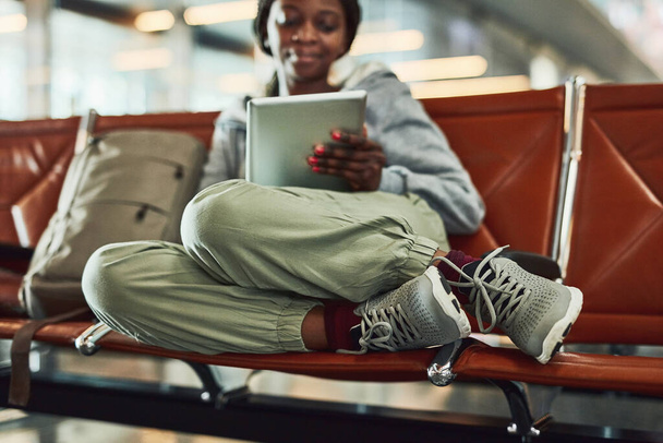 My tablet makes the wait seem shorter. a young woman using her digital tablet at the airport - Fotó, kép