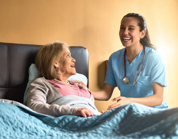 Her positivity is contagious. a female nurse chatting to her senior patient - Photo, image