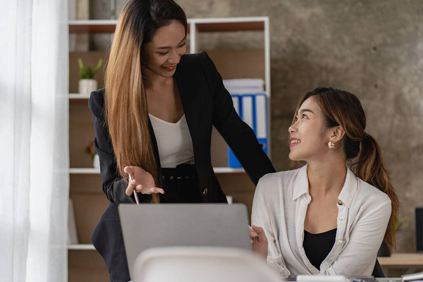 Дві азіатські бізнес-жінки працюють над фінансовим графом і ноутбуком у презентації і огляді бізнес-плану Спільна стратегія фінансового маркетингу в залі зустрічей з новими співробітниками в офісі. - Фото, зображення