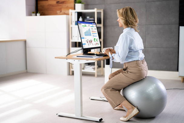 Postura correcta en el escritorio en la oficina usando la bola de la aptitud - Foto, imagen