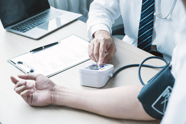 Мужчина врач рука использовать пульсометр для измерения давления пациента, медицинский осмотр концепции. - Фото, изображение