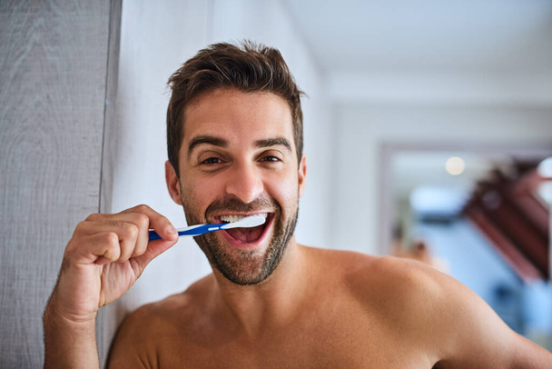 Fresh breath for a fresh day. a handsome young man brushing his teeth at home - Фото, зображення