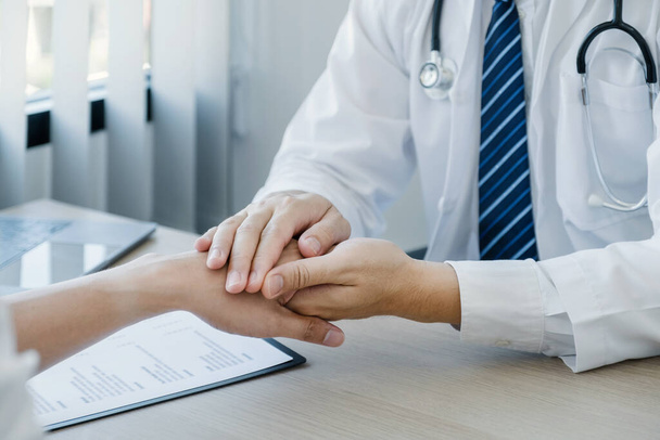 The doctor hands holding patient hand to encourage and explained the health examination results, medical checkup concept. - Photo, image