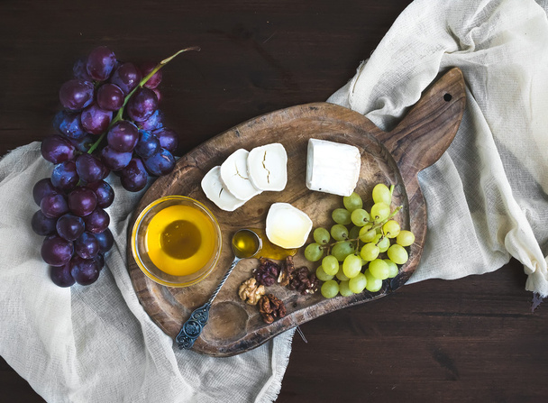 Goat brie cheese with fresh greapes and honey on a rustic wooden - Fotoğraf, Görsel