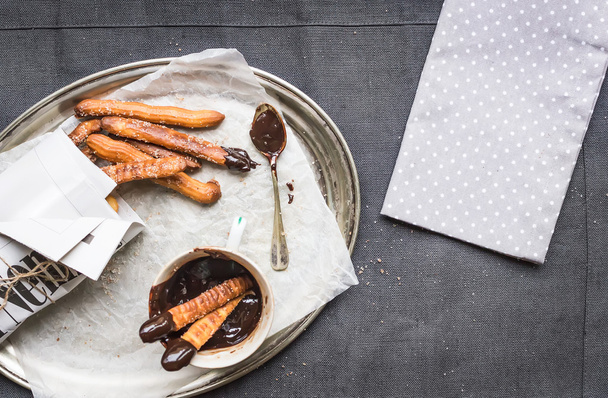 Churros with chocolate sauce on a metal plate - 写真・画像