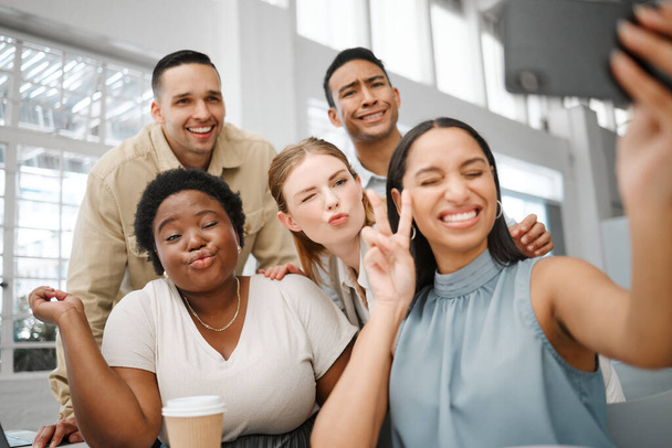 Fun, goofy or playful team selfie on phone and having fun, goofing around or making silly face expressions. Diverse or cheerful group of business friends or creative colleagues posing on social media. - Foto, imagen