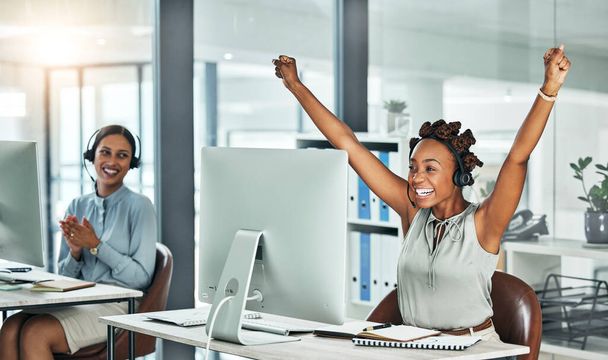 Call centre, cheerful and agent celebrating with arms up at her office desk. Successful, professional and positive customer review or bonus. Helpdesk worker excited with salary performance increase - Foto, immagini