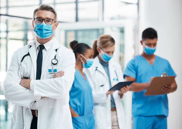 Медичні лікарі, медсестри та медсестри стоять з кованими масками для їхньої безпеки в лікарні. Успішний, професійний і надійний лікар-експерт зі стетоскопом в екстреній
. - Фото, зображення