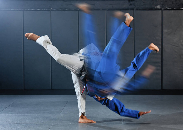 Fitness, strength and men in a karate fight in a gym for martial arts exercise. Action, motion and learning to take down the competition, training to overcome, fight failure and the motivation to win. - Foto, afbeelding