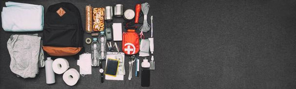 Emergency backpack equipment organized on the table. Documents, water,food, first aid kit and another items needed to survive. - Fotó, kép