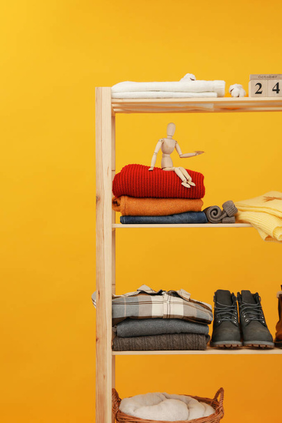 Wooden shelving with clothes, autumn season clothes - Foto, afbeelding