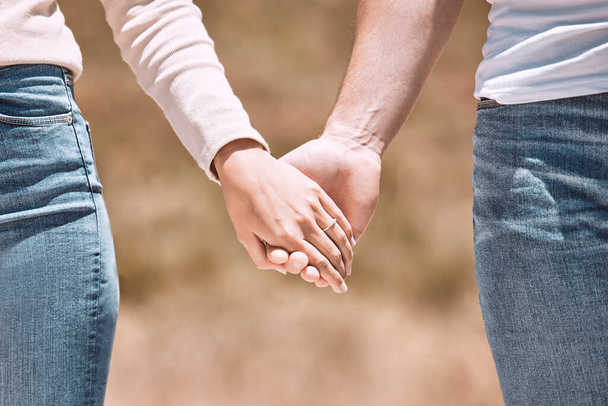 Couple holding hands, love and care showing affection, friendship and romance while on a walk together in nature. Closeup of boyfriend and girlfriend expressing loving, caring and comforting emotion. - Foto, afbeelding