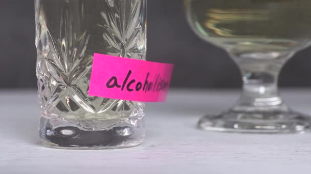 Αλκοολισμός κείμενο σε χαρτί με ένα ποτήρι. Η έννοια της προειδοποίησης αλκοολισμού. - Πλάνα, βίντεο