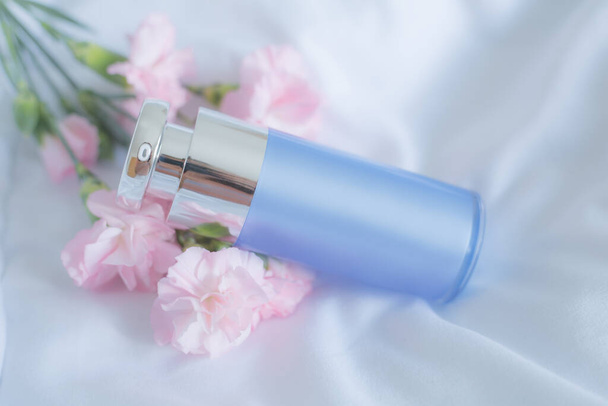 Blue cream tube with pink flowers - Foto, afbeelding
