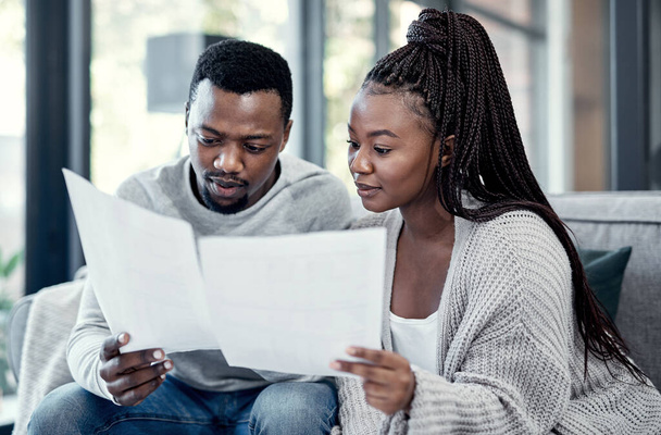 Married couple planning their finance and budget bills or papers together at home. Serious husband and young wife looking at household financial report information and insurance money plan. - Photo, Image