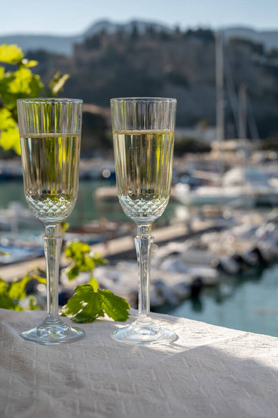 フランスのシャンパン2杯のスパークリングワインとフランスのプロヴァンス、カシスの古い港でカラフルな漁師のボートで見る昼食 - 写真・画像