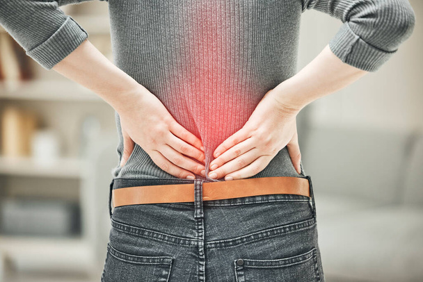 Back, pain and backache of a woman touching and holding a painful area on her body highlighted in red. Closeup of a female feeling strain, ache and discomfort from a glowing muscle injury problem. - Photo, Image