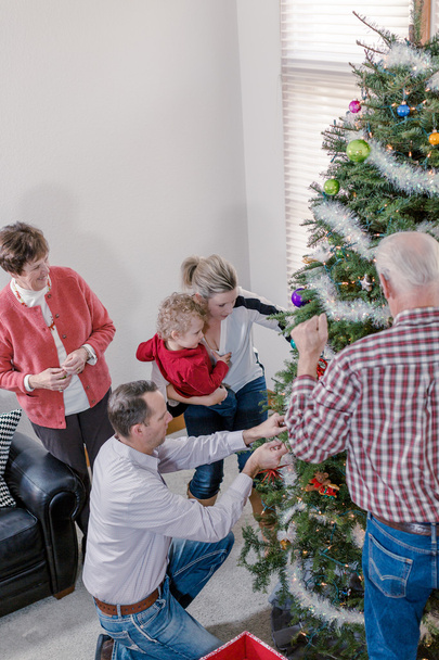 Familie schmückt Weihnachtsbaum - Foto, Bild