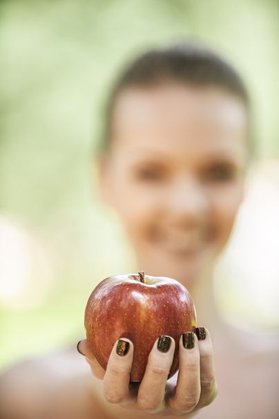 Mujer joven estira manzana
 - Foto, imagen