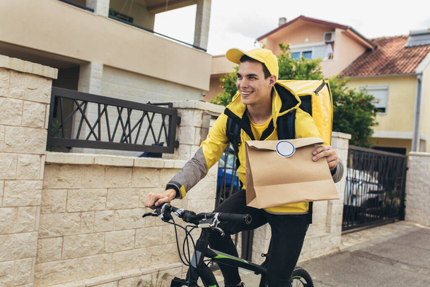 Курьер мужского пола с пакетами доставки велосипедов - Фото, изображение
