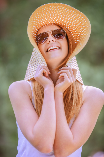 beautiful smiling young woman in wide beach hat - 写真・画像